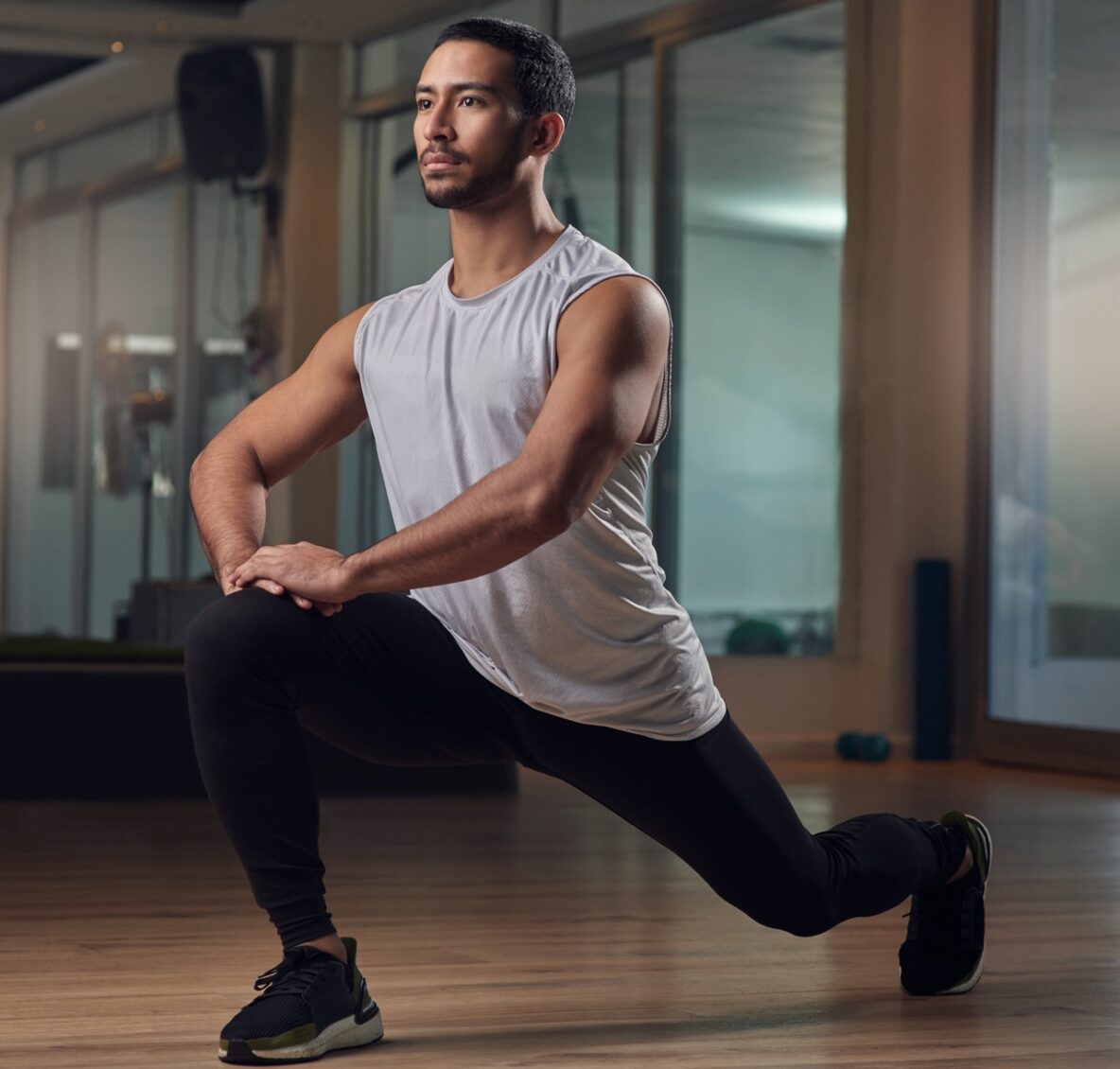 man doing a lunge stretch in a fitness studio